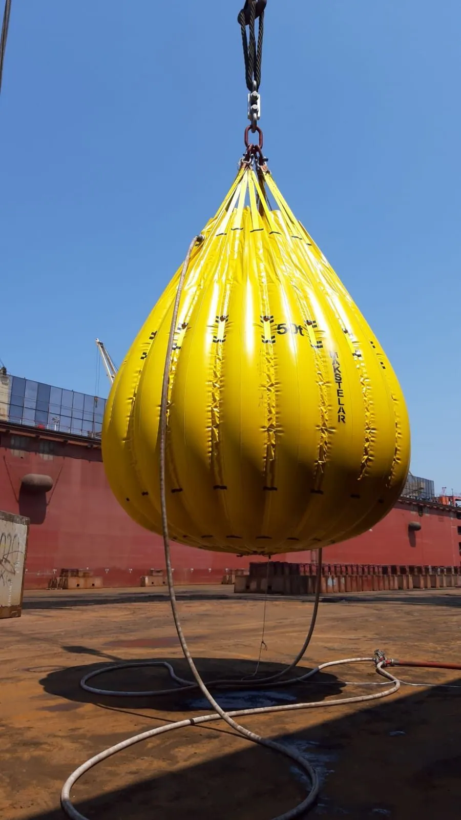 Water-bag test load suspended above a vessel deck